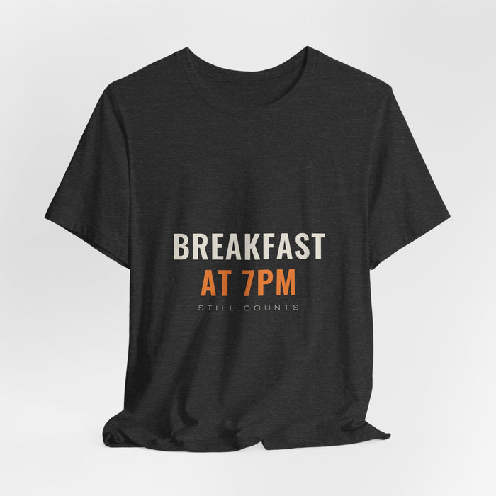 Dark grey heather Breakfast At 7PM t-shirt shown draped, front print visible.