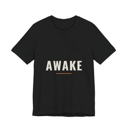 The single word AWAKE in wide-spaced cream capitals over a short orange rule, printed on a black unisex t-shirt.