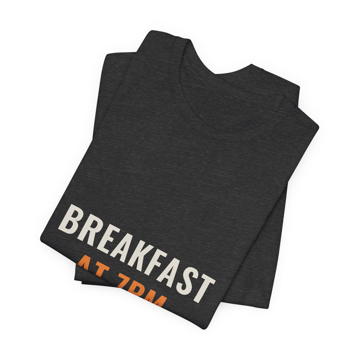 Dark grey heather Breakfast At 7PM t-shirt folded to show the front print at an angle.