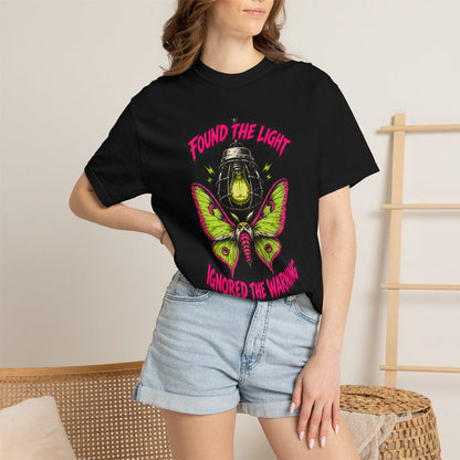 A person wearing the black Found the Light Moth Tee t-shirt with denim shorts.