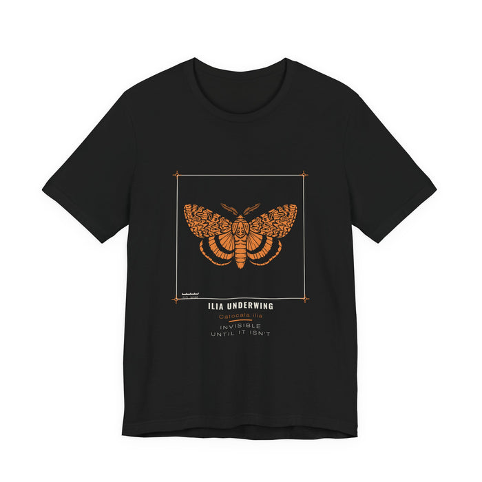 An orange ilia underwing moth with wavy forewing patterning and banded hindwings, drawn as a specimen plate inside a thin bracket frame with a 50 mm scale bar, labelled ILIA UNDERWING / Catocala ilia, printed on a black unisex t-shirt.