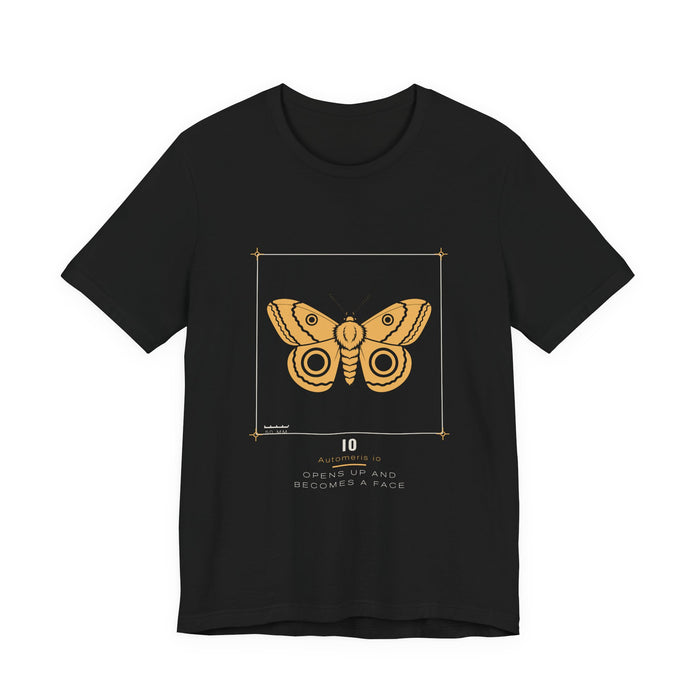 A golden-yellow io moth with two dark ringed eyespots, drawn as a specimen plate inside a thin bracket frame with a 50 mm scale bar, labelled IO / Automeris io, printed on a black unisex t-shirt.