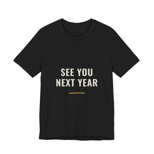 SEE YOU NEXT YEAR in two cream lines above a short orange rule, printed on a black unisex t-shirt.