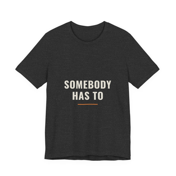 The Somebody Has To design printed on a dark grey heather unisex t-shirt.