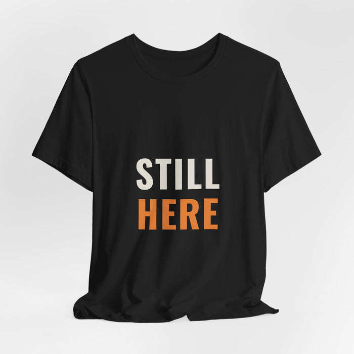 Black Still Here t-shirt shown draped, front print visible.