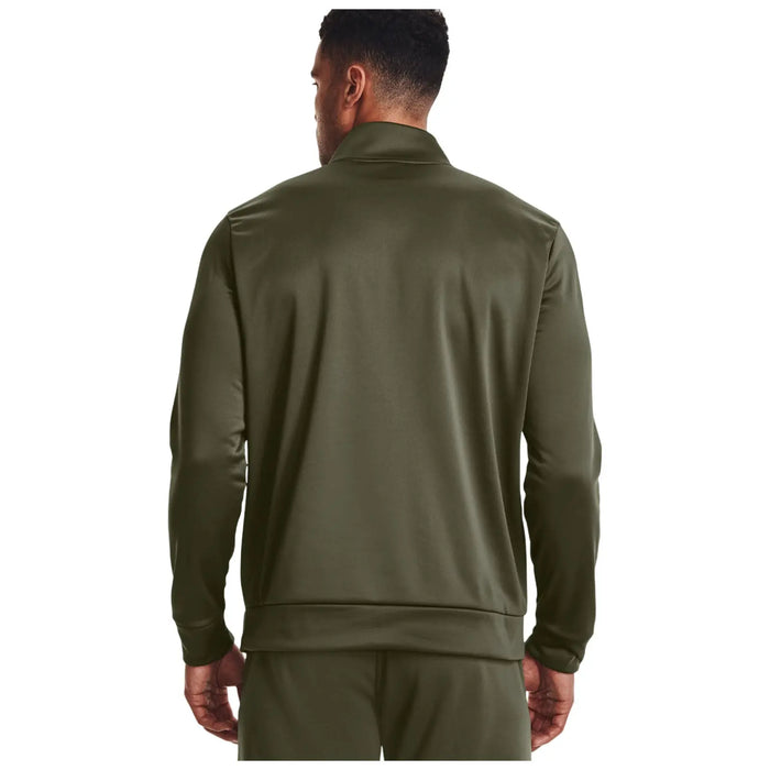 A man is wearing a dark green athletic jacket with a collar and standing with his back facing the viewer in a plain white background.