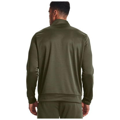 A man is wearing a dark green athletic jacket with a collar and standing with his back facing the viewer in a plain white background.